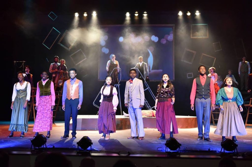 Actors onstage in front of beautiful stage lights performing 