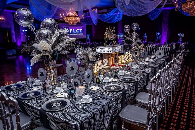 fancy silver gala table with feathers and balloons for 70th celebration 