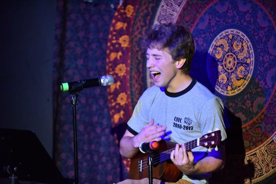 boy plays ukelele and sings onstage 