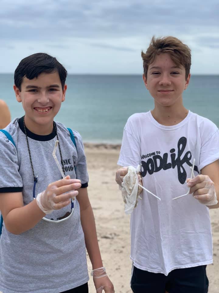 two boys participate in beach clean up